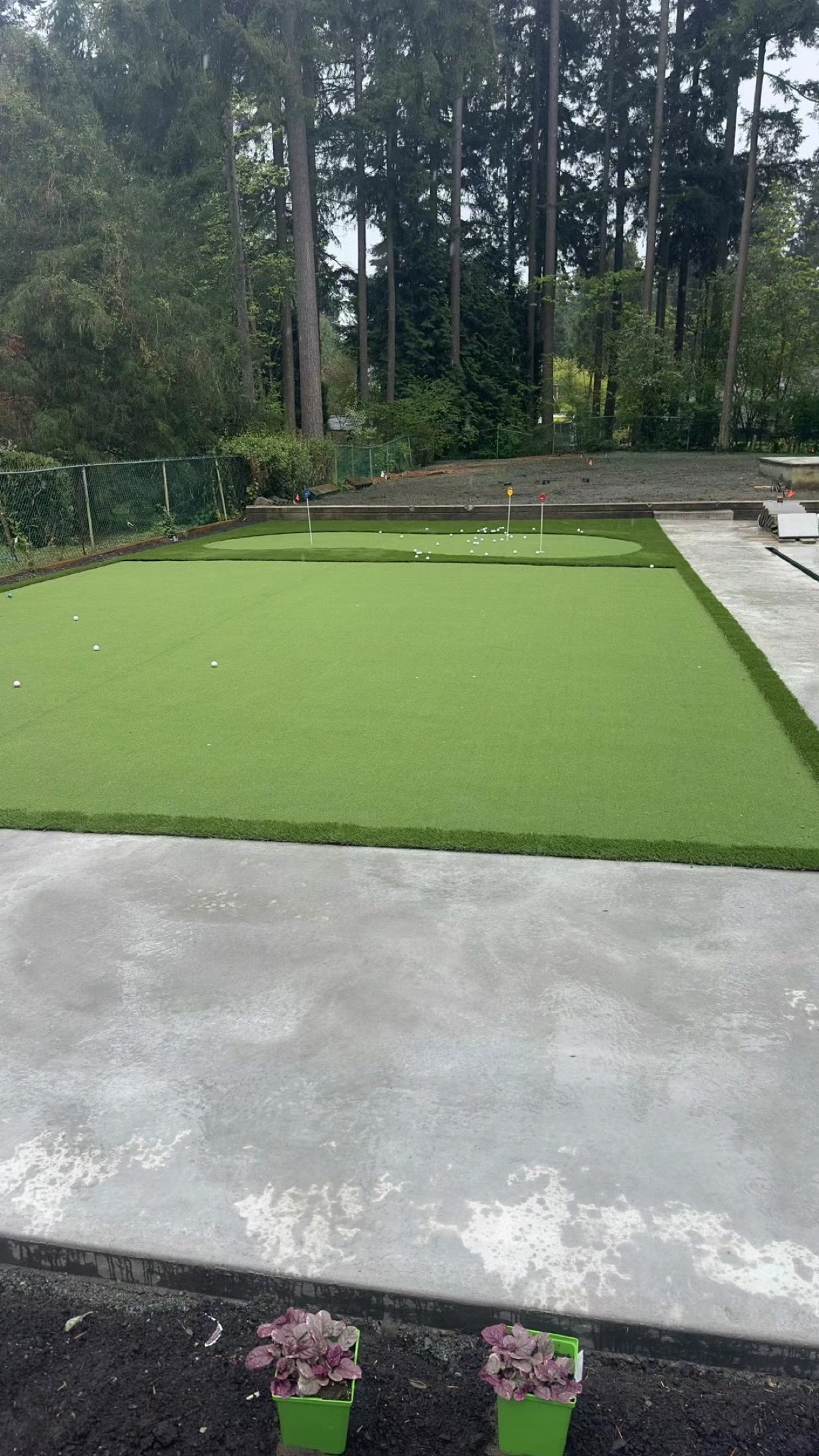 Backyard artificial turf putting green with concrete border