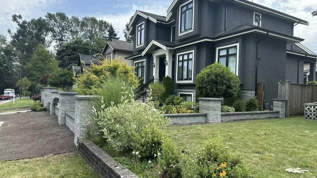 Front yard with stone retaining wall and professional landscaping