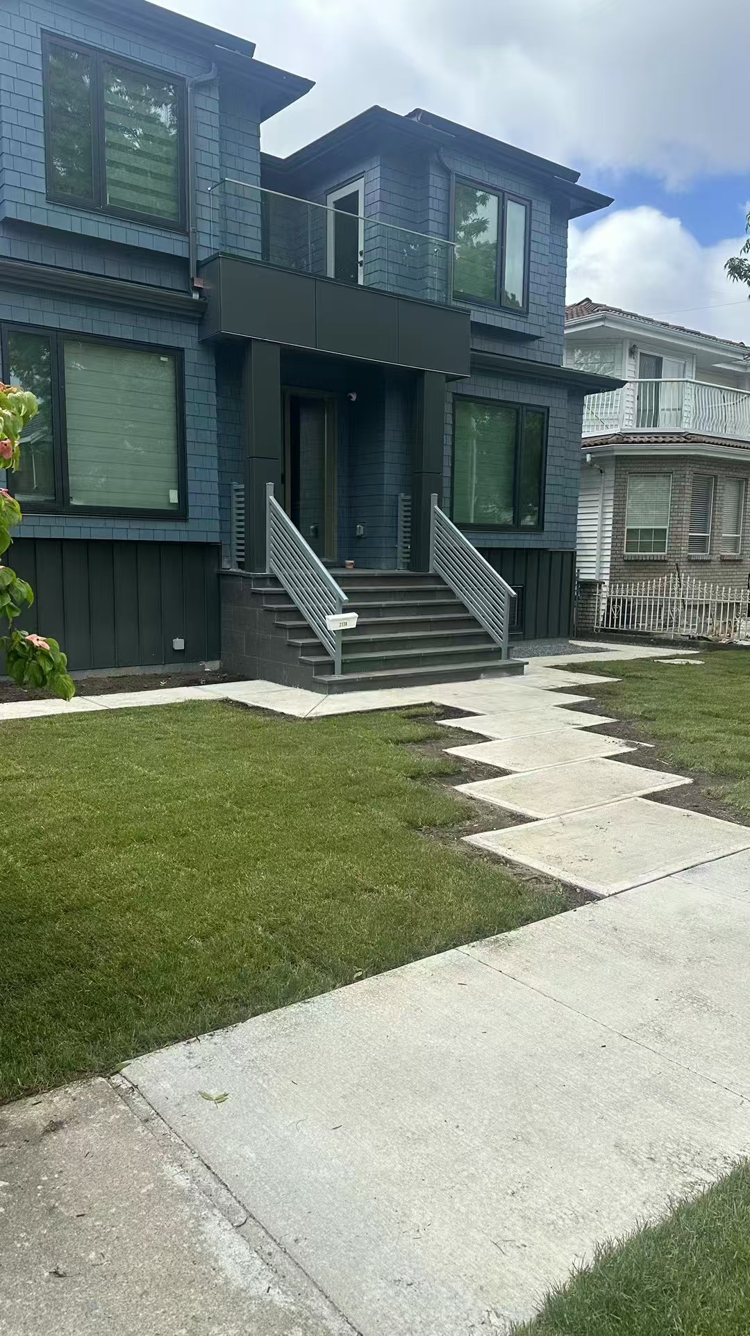 Modern home with concrete walkway and freshly laid sod lawn