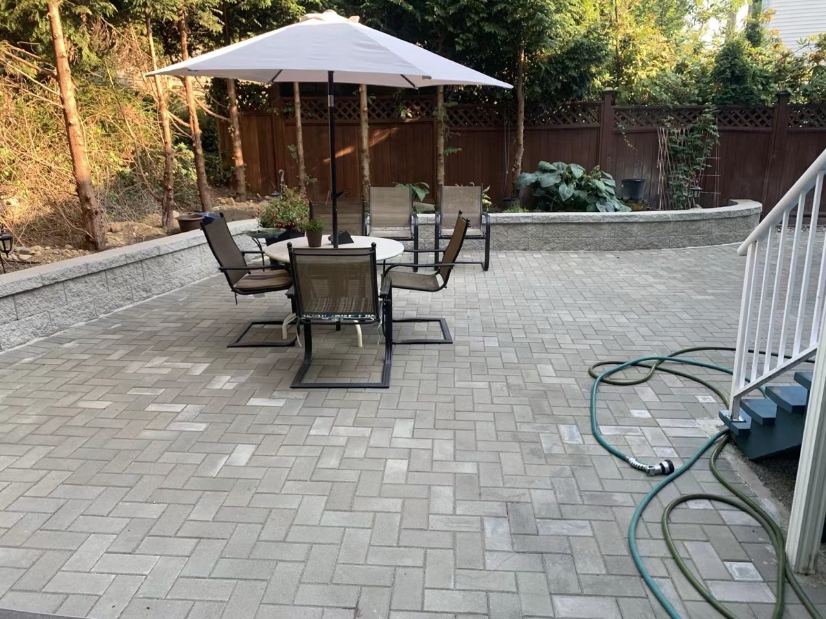 Paver patio with outdoor dining area and retaining wall