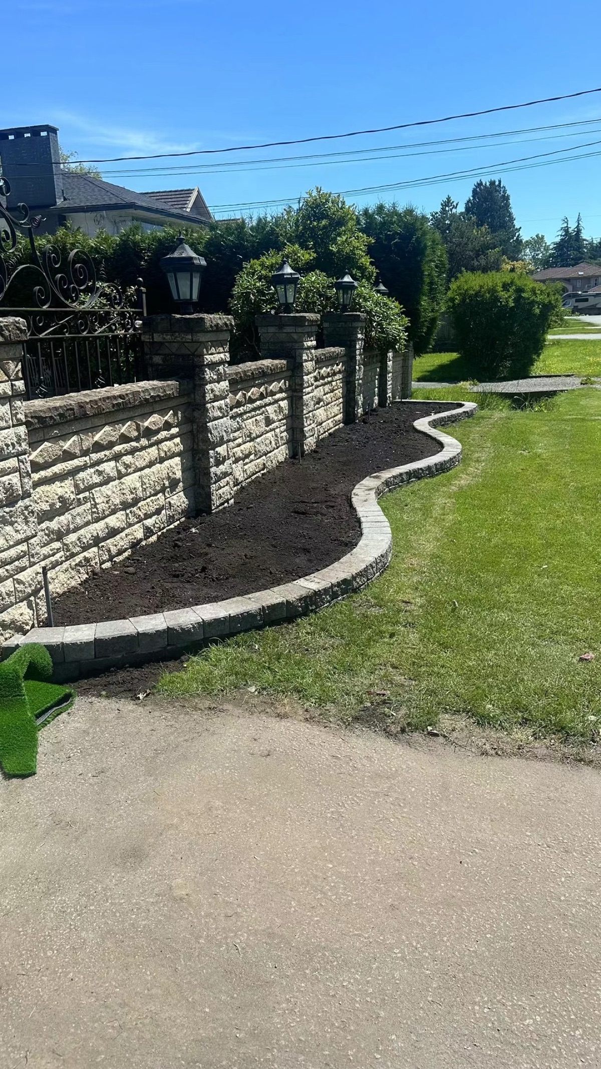 Stone retaining wall with decorative lantern pillars